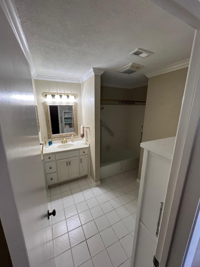 bathroom with tile patterned floors, vanity, crown molding, and a textured ceiling