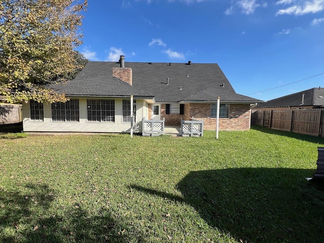 rear view of property with a lawn