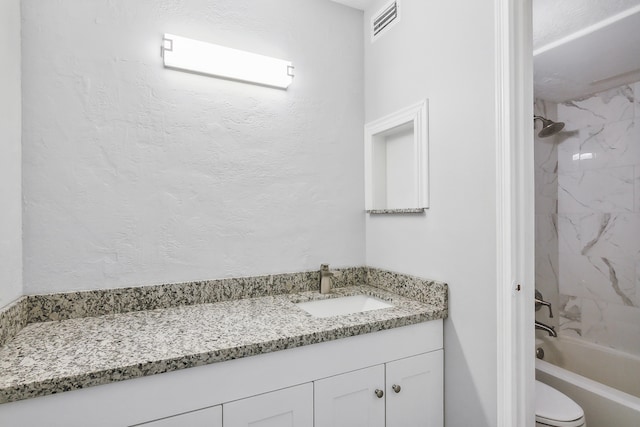 full bathroom with vanity, toilet, and tiled shower / bath