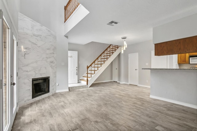 unfurnished living room featuring hardwood / wood-style floors and a high end fireplace