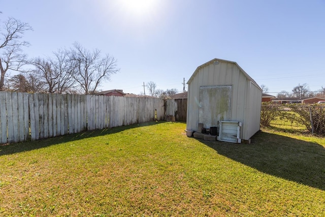 view of yard with an outbuilding, a storage unit, and a fenced backyard