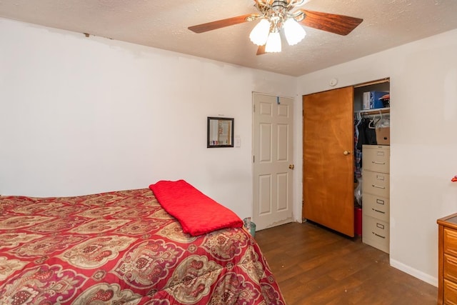 bedroom featuring a textured ceiling, dark wood-type flooring, a closet, and a ceiling fan