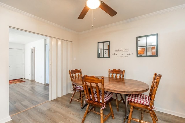 dining area featuring ceiling fan, ornamental molding, and wood finished floors