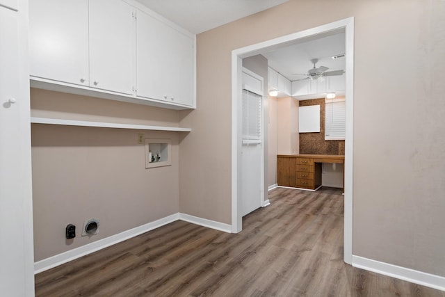 clothes washing area featuring ceiling fan, washer hookup, wood finished floors, baseboards, and cabinet space