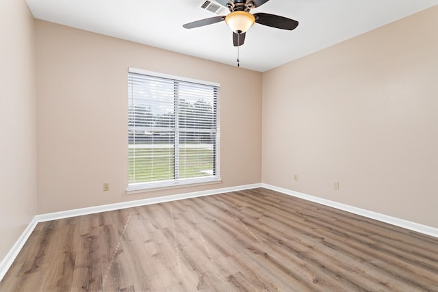 unfurnished room featuring visible vents, baseboards, ceiling fan, and wood finished floors