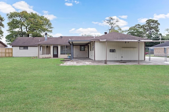 rear view of property with brick siding, a patio, a chimney, a lawn, and fence