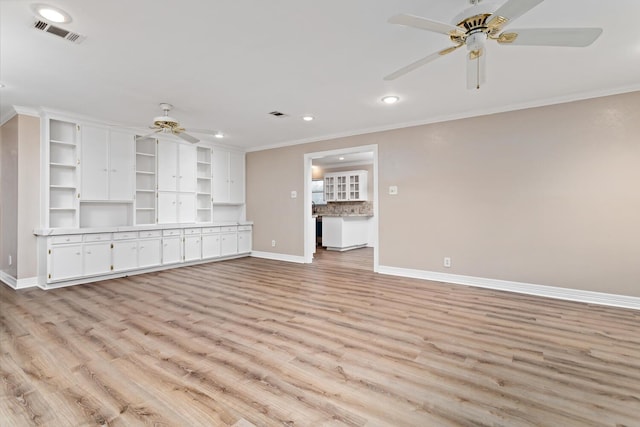 unfurnished living room with light wood finished floors, baseboards, visible vents, and crown molding