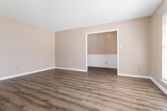 spare room with wood finished floors and baseboards