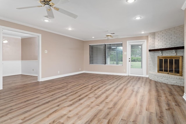 unfurnished living room featuring a fireplace, crown molding, a ceiling fan, wood finished floors, and baseboards