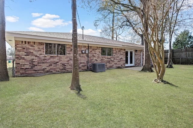 back of property featuring cooling unit and a lawn