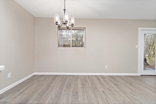 unfurnished dining area featuring a notable chandelier and light wood-type flooring