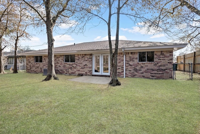 rear view of property with a patio, a yard, and french doors