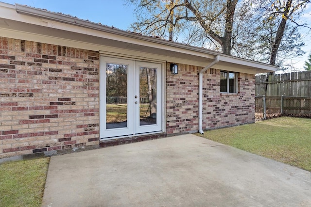 doorway to property with a patio, a yard, and french doors