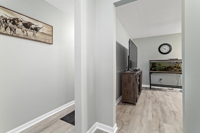 corridor featuring baseboards and wood finished floors