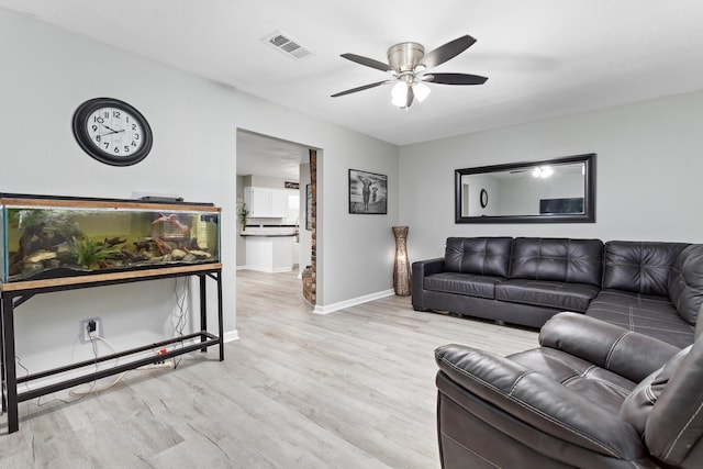 living area featuring ceiling fan, wood finished floors, visible vents, and baseboards