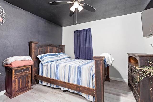 bedroom featuring baseboards, a ceiling fan, and wood finished floors