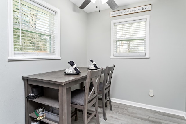 dining space featuring a ceiling fan, plenty of natural light, baseboards, and wood finished floors