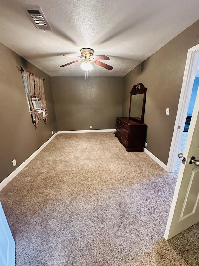 unfurnished bedroom featuring carpet flooring, ceiling fan, and a textured ceiling