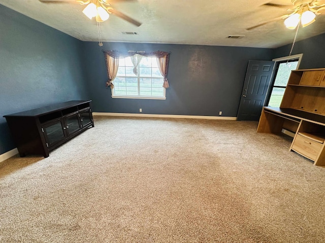 interior space with carpet flooring, a textured ceiling, and ceiling fan