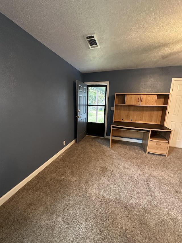 interior space featuring carpet floors and a textured ceiling