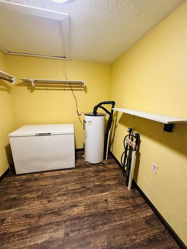 laundry room featuring a textured ceiling, gas water heater, and dark wood-type flooring