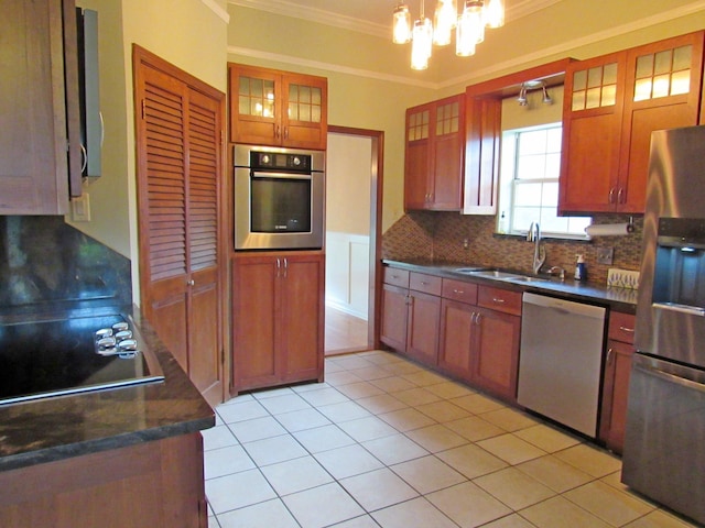 620 20th St, Beaumont, TX 77706 - kitchen featuring appliances with stainless steel finishes, crown molding, dark countertops, decorative backsplash, and a chandelier
