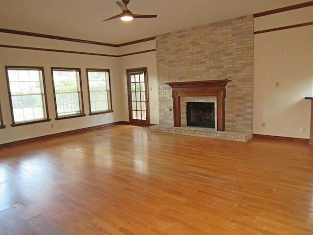 620 20th St, Beaumont, TX 77706 - unfurnished living room with a ceiling fan, light wood-style flooring, a brick fireplace, and ornamental molding