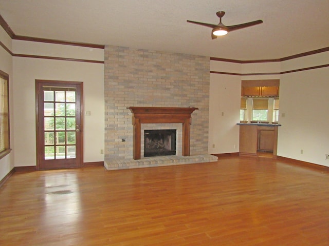 620 20th St, Beaumont, TX 77706 - unfurnished living room with wood finished floors, crown molding, ceiling fan, and a fireplace