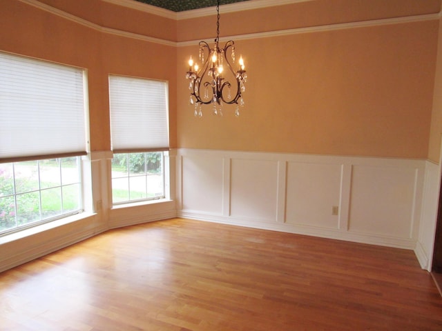 620 20th St, Beaumont, TX 77706 - unfurnished room featuring a decorative wall, a chandelier, ornamental molding, wainscoting, and light wood finished floors