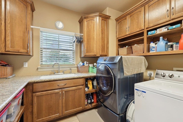 clothes washing area featuring independent washer and dryer, a sink, and cabinet space