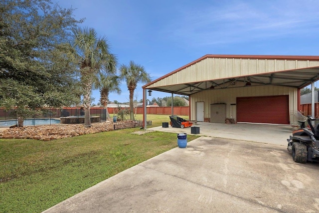 view of yard featuring a garage, a fenced in pool, and fence