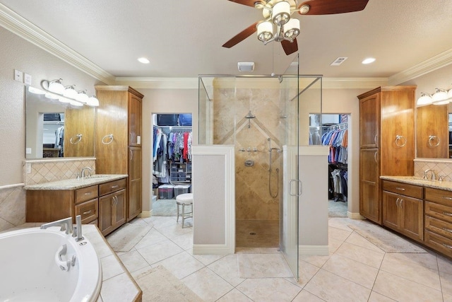 full bathroom featuring ornamental molding, a stall shower, and two vanities