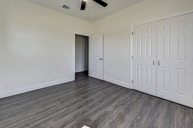 unfurnished bedroom featuring ceiling fan, a closet, and dark wood-type flooring