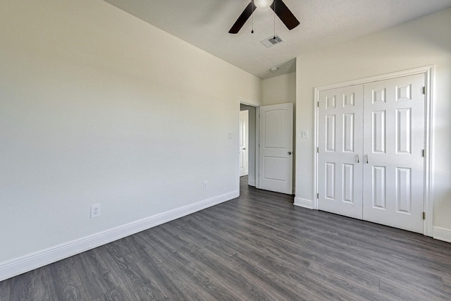 unfurnished bedroom featuring ceiling fan, dark hardwood / wood-style floors, and a closet