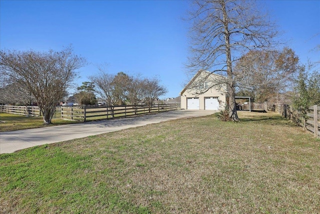 view of yard featuring a garage and a rural view