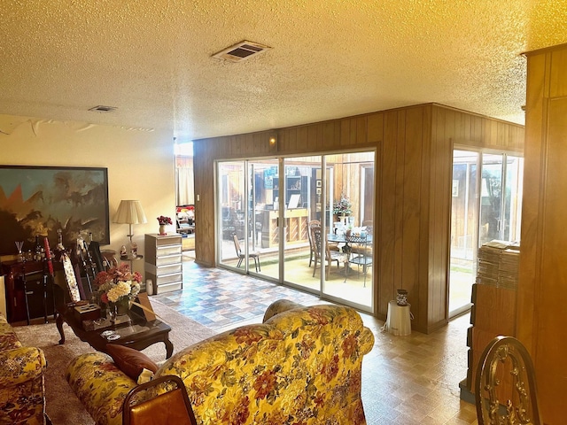 living room with wood walls and a textured ceiling