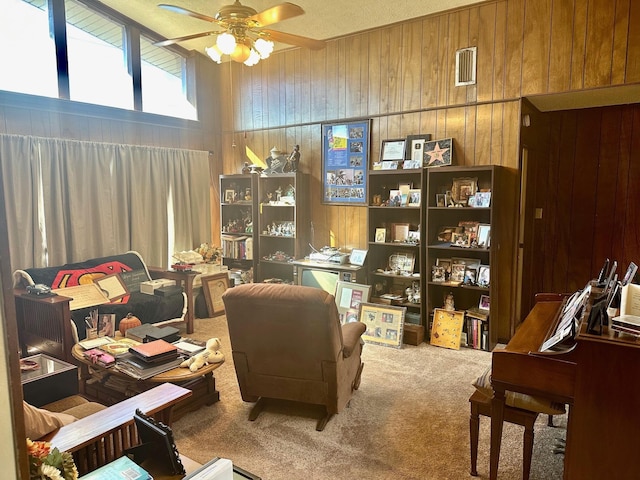 interior space featuring ceiling fan, carpet, and wood walls