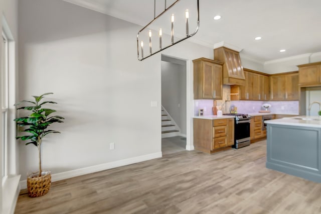 kitchen featuring light wood-type flooring, electric range oven, crown molding, and sink