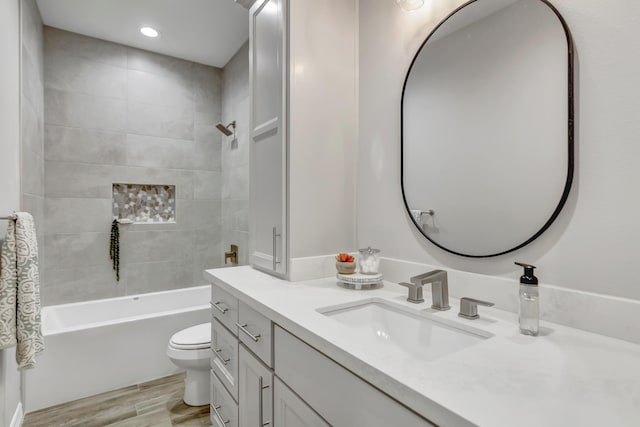 full bathroom featuring vanity, toilet, wood-type flooring, and tiled shower / bath combo