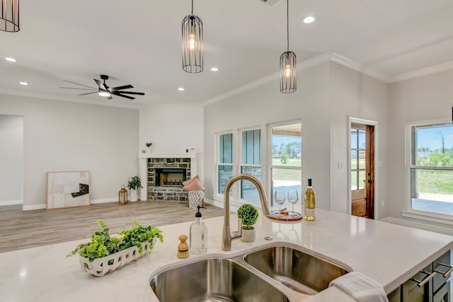 kitchen featuring a fireplace, pendant lighting, plenty of natural light, and sink