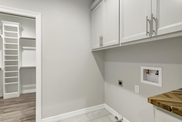 laundry room with hookup for a washing machine, light tile patterned floors, cabinets, and hookup for an electric dryer