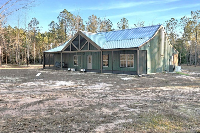 chalet / cabin featuring board and batten siding, central AC, and metal roof