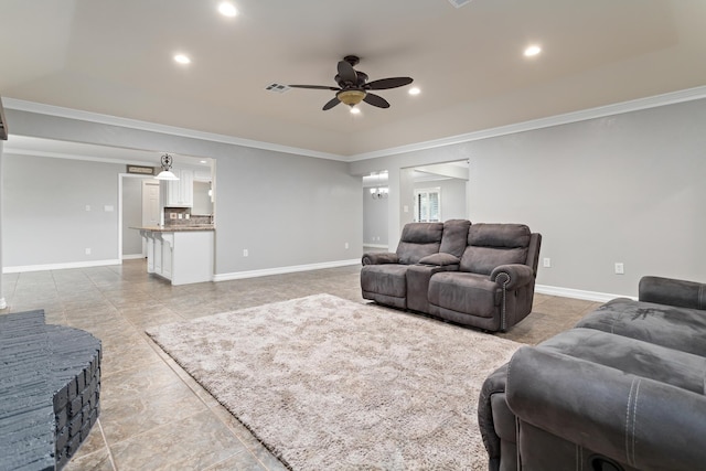 tiled living room with ceiling fan and ornamental molding