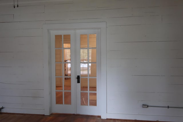 interior space featuring french doors, dark hardwood / wood-style floors, and wood walls