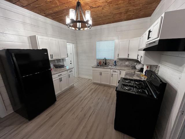 kitchen featuring wood ceiling, black appliances, pendant lighting, white cabinetry, and wood walls