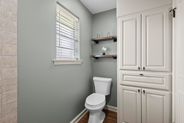 bathroom with wood finished floors, baseboards, and toilet