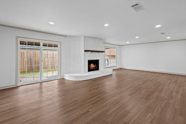 unfurnished living room with wood finished floors, visible vents, and plenty of natural light