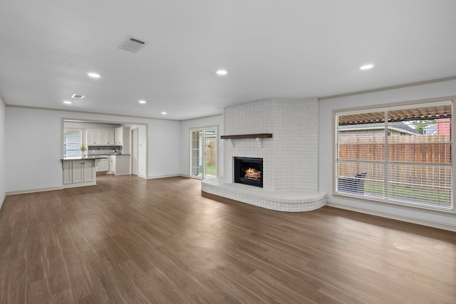 unfurnished living room with baseboards, wood finished floors, and visible vents