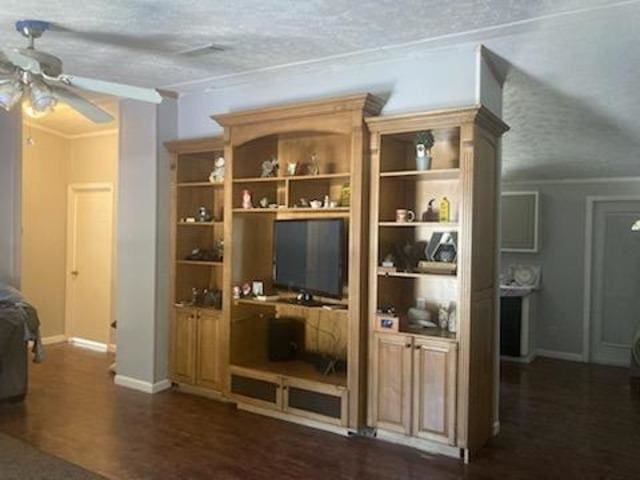 interior space featuring built in shelves, ceiling fan, dark wood-type flooring, and a textured ceiling