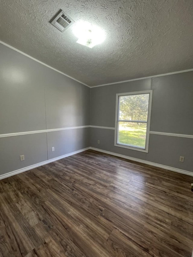 unfurnished room featuring a textured ceiling, dark hardwood / wood-style floors, and ornamental molding